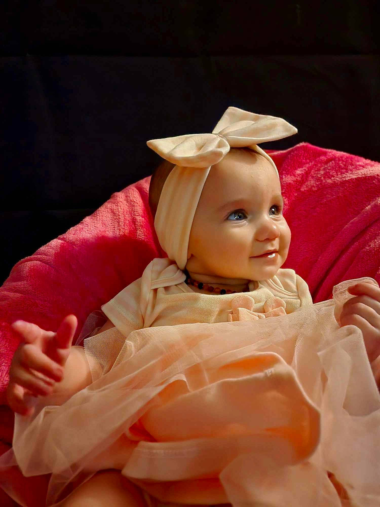 Sabrina is registered to the contest to win money with this photo: baby, baby_toddler_clothing, cheek, child, doll, dress, event, fashion_accessory, happy, headpiece, human_body, mythical_creature, peach, person, pink, skin, sleeve, smile, thumb, toddler