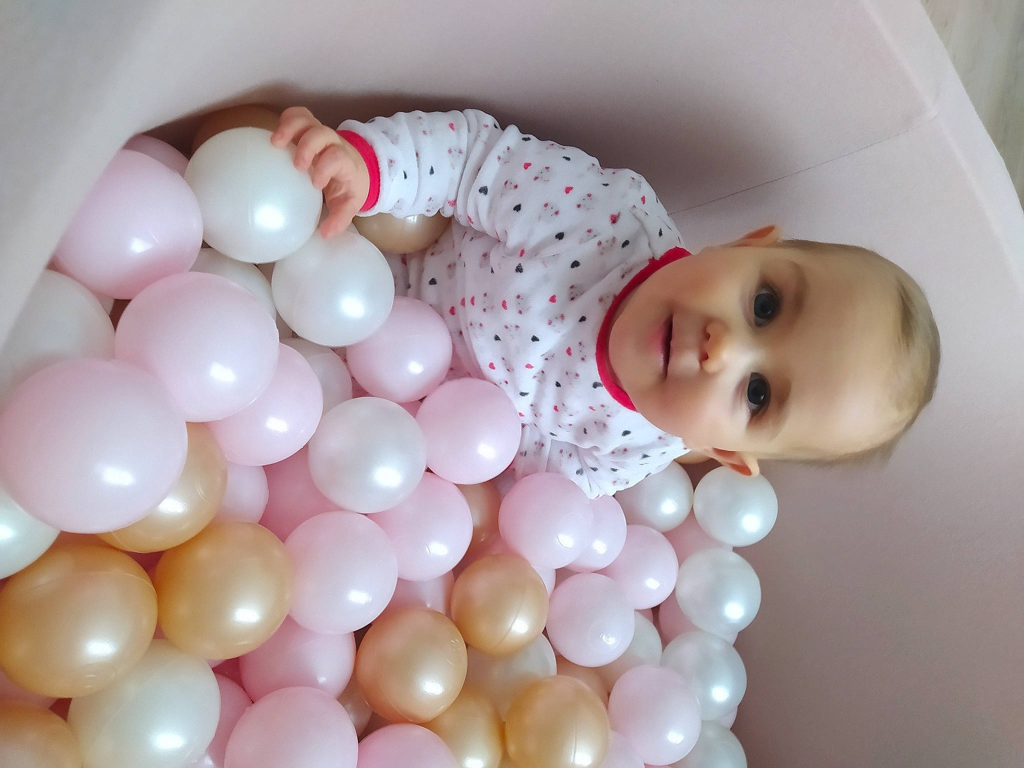 Calie participe au concours pour gagner de l'argent avec cette photo : baby, baby_toddler_clothing, ball, balloon, child, circle, comfort, event, fun, party_supply, pattern, peach, person, pink, toddler, toy, white