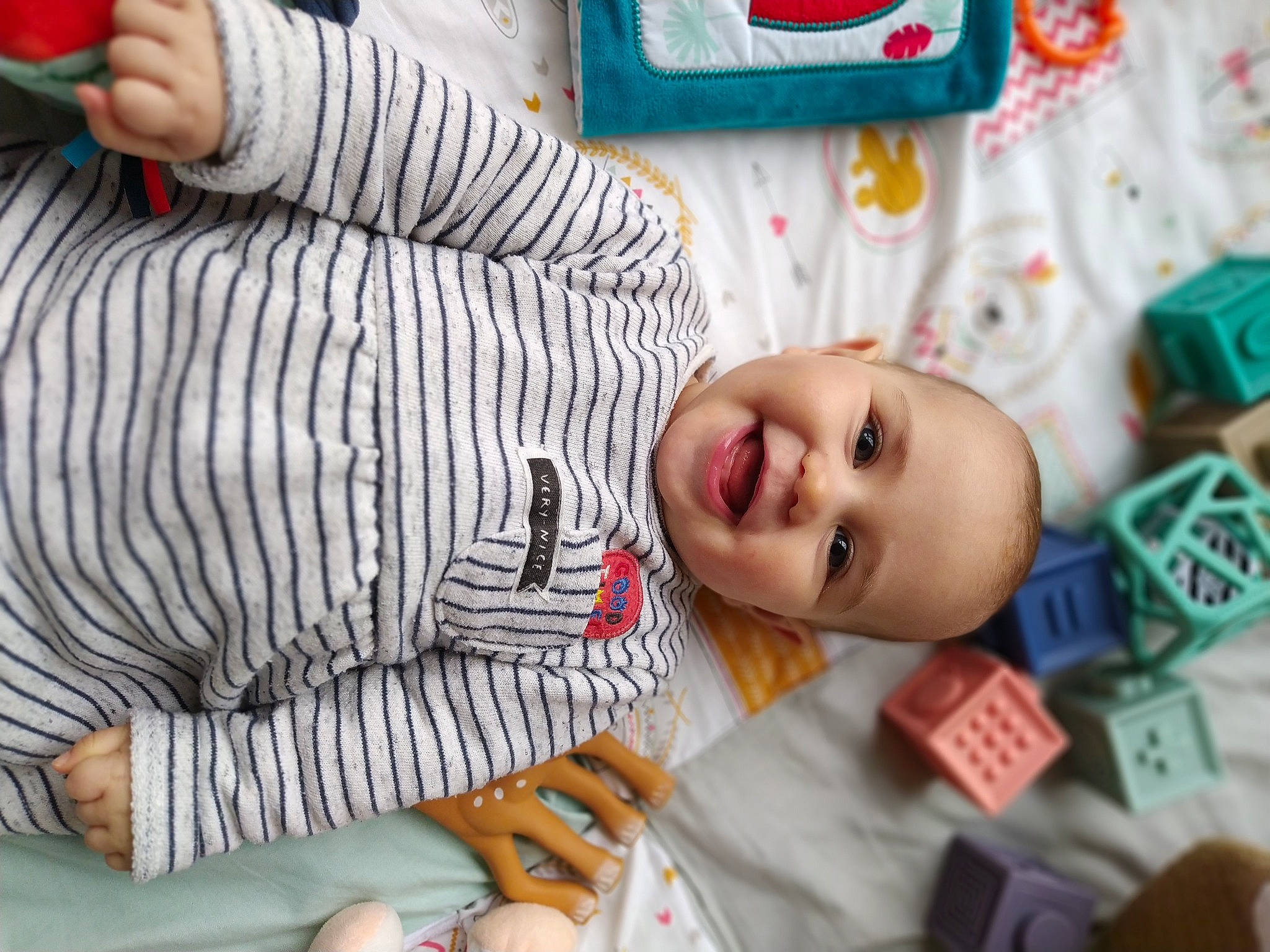 Calie a rejoint le concours — aidez-le/la à gagner de superbes lots ! baby, baby_toddler_clothing, cheek, child, finger, flooring, fun, happy, joy, leisure, mouth, nose, pattern, person, play, room, sleeve, smile, textile, toddler