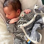 Isaac participe au concours pour gagner de l'argent avec cette photo : newborn, baby, sleeping, pajamas, striped_clothing, blanket, soft_toy, cozy, infant, cute, peaceful, indoor, bed, head, hand, face, resting, child, warm, comfort