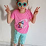 Cassie a rejoint le concours — aidez-le/la à gagner de superbes lots ! child, indoor, peace_sign, sunglasses, pink_shirt, cartoon_characters, shorts, black_socks, smile, standing, tile_floor, wall, playful, fashion, happy, person, casual_clothing, accessory, youth, portrait
