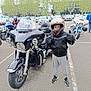 Logan participe au concours pour gagner de l'argent avec cette photo : child, motorcycle, helmet, leather_jacket, gloves, parking_lot, trees, car, vehicle, outdoor, person, asphalt, thumbs_up, casual_clothing, sneakers, helmet_visor, motorbike_event, road, transportation, safety_gear