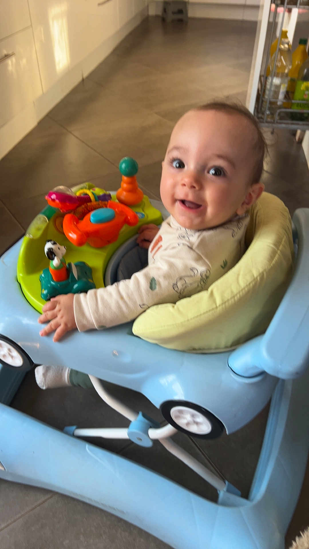 Keyden participe au concours pour gagner de l'argent avec cette photo : baby, walker, toy, smile, child, indoor, floor, cushion, play, happy, person, furniture, clothing, face, head, expression, colorful, seat, kitchen, curious