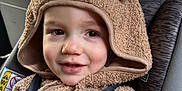 Coleson is registered to the contest to win money with this photo: toddler, child, car_seat, car_interior, hoodie, fuzzy_clothing, brown, seatbelt, smile, face, infant, young_child, cute, indoors, closeup, safety, window, seat, straps, baby