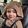 toddler, child, car_seat, car_interior, hoodie, fuzzy_clothing, brown, seatbelt, smile, face, infant, young_child, cute, indoors, closeup, safety, window, seat, straps, baby