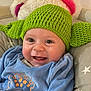 baby, blue_clothing, child, cozy, cushion, cute, eyes, face, green_hat, happy, indoor, infant, knitted_hat, mouth, plush, portrait, seated, smiling, star_pattern, teeth