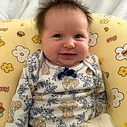 Aubrey joined the competition — help win amazing prizes! baby, infant, child, smiling, happy, portrait, sitting, floral_cushion, yellow, blanket, teddy_bears, patterned_clothing, bow, indoors, cozy, bedhead, face, eyes, baby_seat, photography
