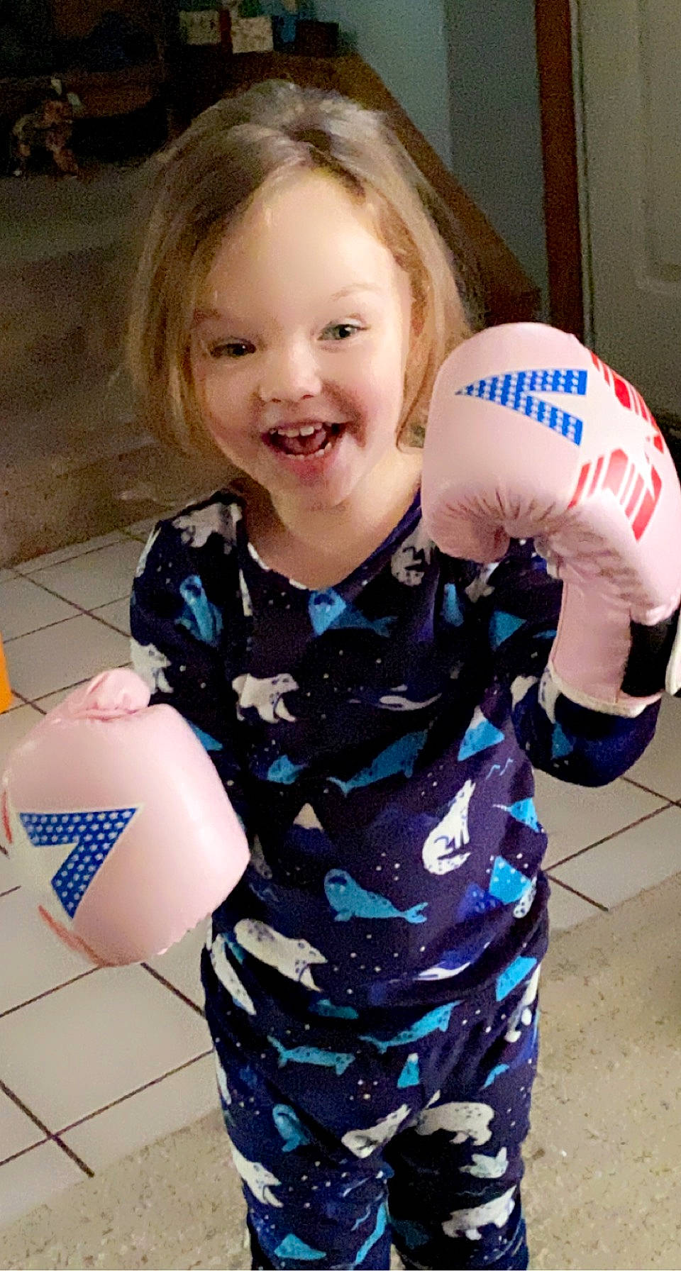 Amora is registered to the contest to win money with this photo: baby_toddler_clothing, ball, child, electric_blue, face, fun, glove, happy, joy, logo, pattern, person, personal_protective_equipment, play, product, sitting, sleeve, smile, sports_equipment, sports_gear