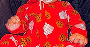 Leslie is registered to the contest to win money with this photo: baby, infant, pacifier, red_onesie, headband, car_seat, black_background, sitting, cute, milk_carton_pattern, cookie_pattern, foot, hand, closeup, indoors, child, adorable, portrait, comfort, pink_heart