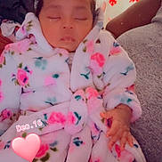 Leslie joined the competition — help win amazing prizes! baby, sleeping, child, robe, floral_pattern, bow, headwear, hand, couch, blanket, indoor, decorations, snowflake, red, pink, heart, date_overlay, cozy, resting, person
