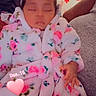 baby, sleeping, child, robe, floral_pattern, bow, headwear, hand, couch, blanket, indoor, decorations, snowflake, red, pink, heart, date_overlay, cozy, resting, person