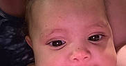 Brianna is registered to the contest to win money with this photo: baby, face, child, infant, cute, tongue, chubby_cheeks, curly_hair, close_up, skin, person, portrait, expression, looking_at_camera, indoors, human, head, smiling, young, warm_lighting