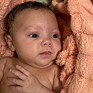 Brianna is registered to the contest to win money with this photo: baby, infant, child, face, skin, hand, eyes, towel, peach_color, soft_texture, newborn, portrait, cute, curious, close_up, expression, human, indoors, resting, newborn_baby