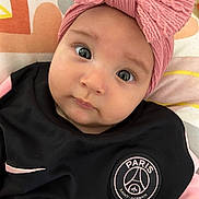Leya-Maria a rejoint le concours — aidez-le/la à gagner de superbes lots ! baby, infant, face, headband, pink, black_clothing, jersey, sportswear, logo, cushion, pattern, eyes, cute, portrait, closeup, soft_lighting, indoor, child, young, apparel