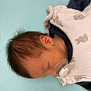 Léon a rejoint le concours — aidez-le/la à gagner de superbes lots ! baby, sleeping, pacifier, blanket, infant, peaceful, cozy, face, head, hair, skin, child, newborn, resting, blue_background, clothing, nap, cute, soft, indoors