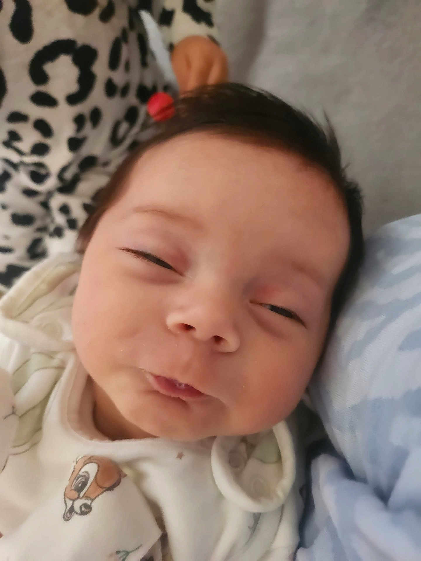 Amelie is registered to the contest to win money with this photo: baby, close_up, face, infant, smile, sleepy, cute, blanket, pattern, soft, clothing, child, portrait, indoors, resting, young, expression, cozy, head, skin