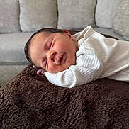 Amelie is registered to the contest to win money with this photo: newborn, baby, sleeping, blanket, couch, infant, white_clothing, peaceful, indoors, soft_texture, portrait, resting, child, cozy, cute, face, person, small, relaxation, home