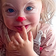 Anna participe au concours pour gagner de l'argent avec cette photo : toddler, child, face_paint, blue_eyes, finger_in_mouth, pink_clothing, polka_dot, pacifier_clip, close_up, curly_hair, playful, smile, indoor, person, cute, young_child, portrait, hand, baby, innocent