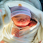 Sehrish Alam is registered to the contest to win money with this photo: baby, beanie, blanket, child, closeup, cozy, cute, face, hand, indoors, infant, newborn, peaceful, portrait, resting, sleeping, soft, toddler, warm, wrapped