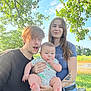 baby, bench, casual_clothing, child, family, grass, happy, holding, nature, outdoor, people, person, portrait, sky, smile, summer, sunlight, tattoo, trees, young_adult