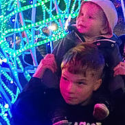 Ace is registered to the contest to win money with this photo: celebration, child, children, colorful, face, festive, fun, glow, holiday, hood, jacket, lights, neon, night, outdoor, person, shoulders, smile, winter, youth