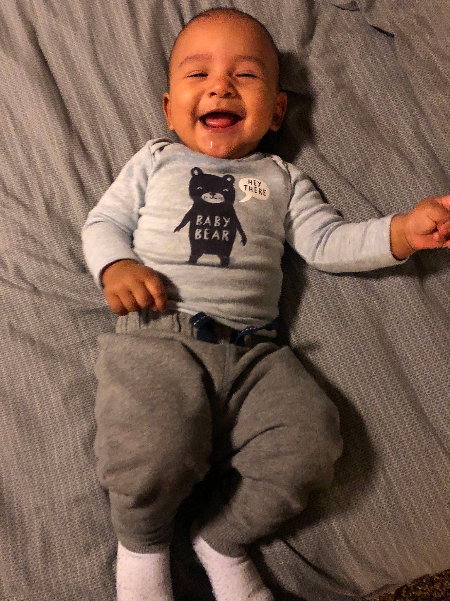 Osias is registered to the contest to win money with this photo: arm, boy, child, cool, human, infant, joint, person, product, sitting, sleeve, smile, standing, t_shirt, toddler