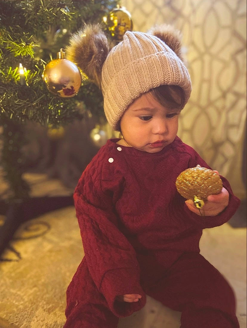 Amelia joined the competition — help win amazing prizes! baby_toddler_clothing, cap, child, christmas, christmas_ornament, christmas_tree, event, facial_expression, fun, happy, headwear, holiday, leaf, ornament, people_in_nature, person, plant, toddler, tradition, tree