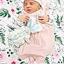 baby, baby_outfit, blanket, child, closeup, cozy, cute, floral_blanket, hat, indoors, infant, newborn, peaceful, pink_clothing, portrait, resting, sleeping, small_hands, soft_toy, toy_bunny
