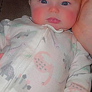 Andi is registered to the contest to win money with this photo: baby, infant, child, onesie, pajamas, zipper, rosy_cheeks, blue_eyes, eyelashes, hand, couch, close_up, portrait, indoor, soft_lighting, cute, gaze, skin, cozy, dinosaur_print