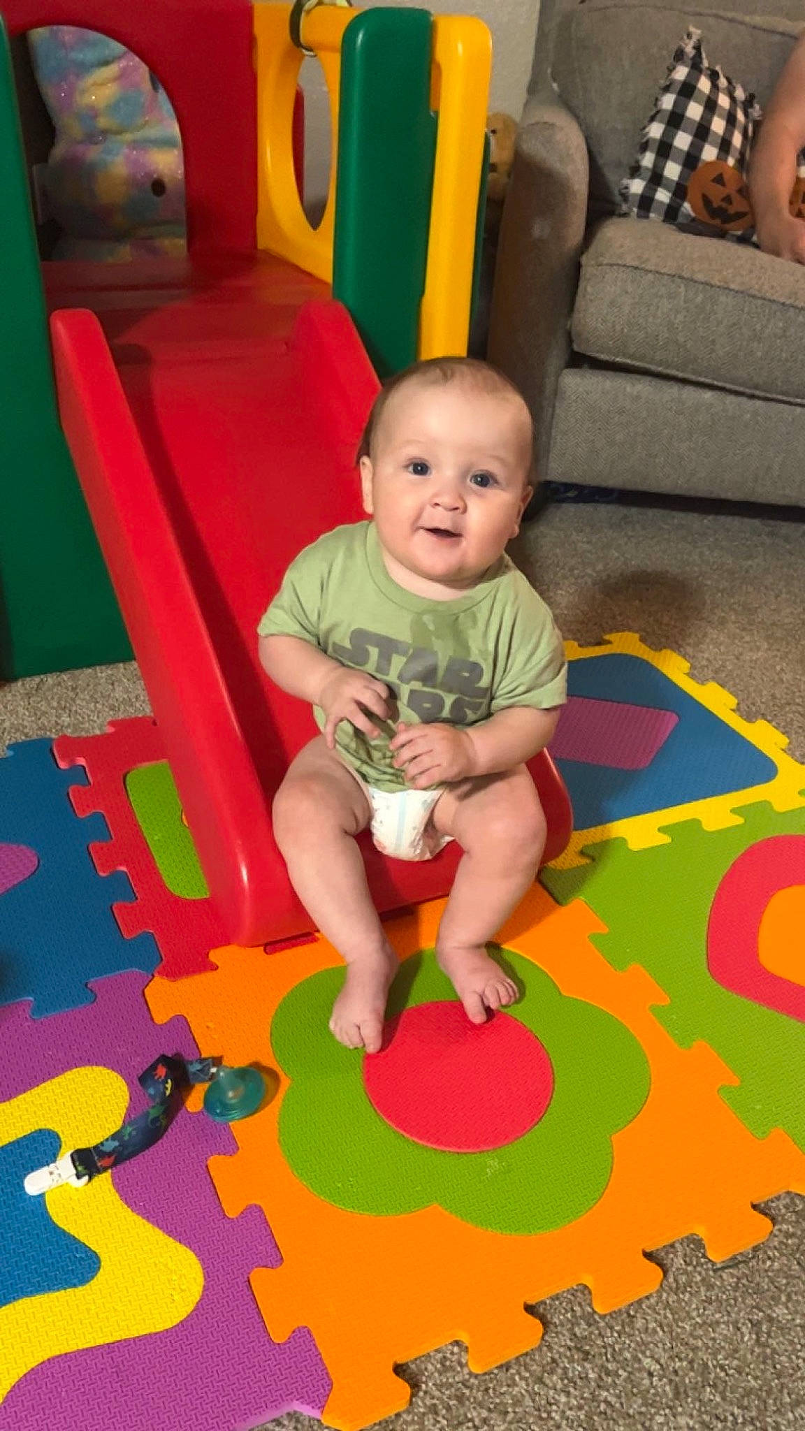 Elliot is registered to the contest to win money with this photo: art, baby, baby_products, baby_toddler_clothing, baby_toys, carpet, chair, child, floor, flooring, fun, leisure, person, play, playmat, product, room, sitting, smile, toddler