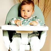 Marceau a rejoint le concours — aidez-le/la à gagner de superbes lots ! toddler, child, high_chair, socks, food, pampas_grass, green_clothing, indoor, modern_furniture, baby, person, cute, portrait, seat, hands, legs, light, cozy, striped_socks, young_child