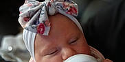 Evelyn is registered to the contest to win money with this photo: animal_print, baby, bib, bottle, bow, child, cozy, cute, face, feeding, hand, headband, indoor, infant, milk, newborn, pastel, portrait, sleepy, soft_light