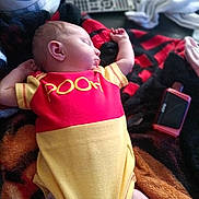 Evelyn joined the competition — help win amazing prizes! baby, sleeping, onesie, pooh, blanket, remote_control, infant, clothing, cute, rest, home, relaxation, child, cozy, soft, person, indoors, peaceful, small, lying_down