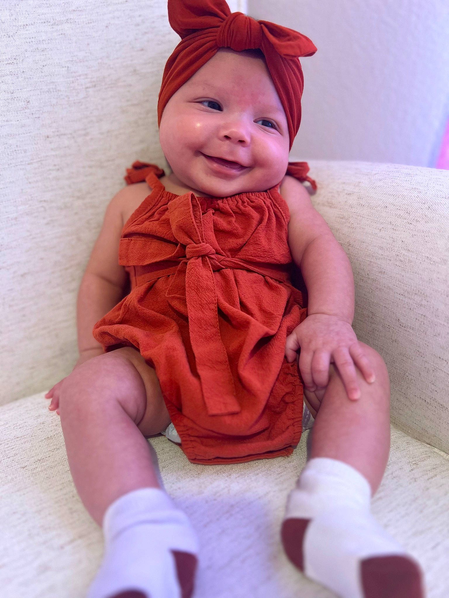 Charlotte is registered to the contest to win money with this photo: arm, baby, baby_toddler_clothing, cap, clothing, comfort, costume_hat, face, facial_expression, finger, head, headwear, human_body, joy, lip, outerwear, person, pink, skin, sleeve
