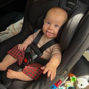 Loki is registered to the contest to win money with this photo: baby, car_seat, child, tongue_out, blue_eyes, red_shorts, seatbelt, car_interior, toy, plush_toy, cute, smiling, sitting, infant, playful, sunlight, seat, child_safety, happy, casual