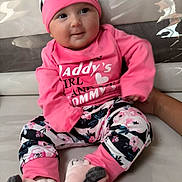 Johanna participe au concours pour gagner de l'argent avec cette photo : baby, child, comfortable, couch, cozy, cute, floral_pants, footwear, hand, happy, hat, home, indoor, infant, person, pink_clothing, portrait, sitting, smiling, soft_toys