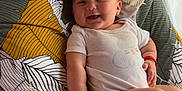 Johanna participe au concours pour gagner de l'argent avec cette photo : baby, baby_accessories, baby_clothing, blanket, child, cute, face, happy, indoors, infant, leaf_pattern, lying_down, onesie, pacifier, person, pillow, sleeping_area, smiling, soft_toys, toddler
