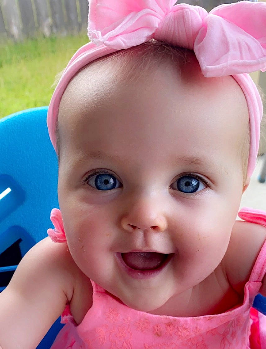 Alyvia is registered to the contest to win money with this photo: baby, beauty, cheek, child, close_up, ear, eye, eyebrow, face, forehead, hair_accessory, head, headgear, lip, mouth, nose, person, pink, skin, smile