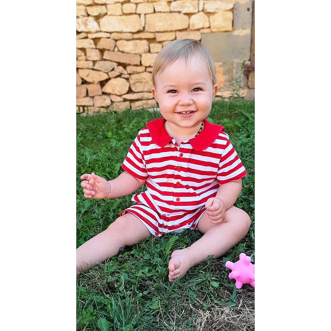 Kenzo a rejoint le concours — aidez-le/la à gagner de superbes lots ! baby, baby_toddler_clothing, child, clothing, grass, happy, human_body, joy, magenta, pattern, people_in_nature, person, plant, portrait_photography, recreation, rectangle, sitting, sleeve, smile, t_shirt