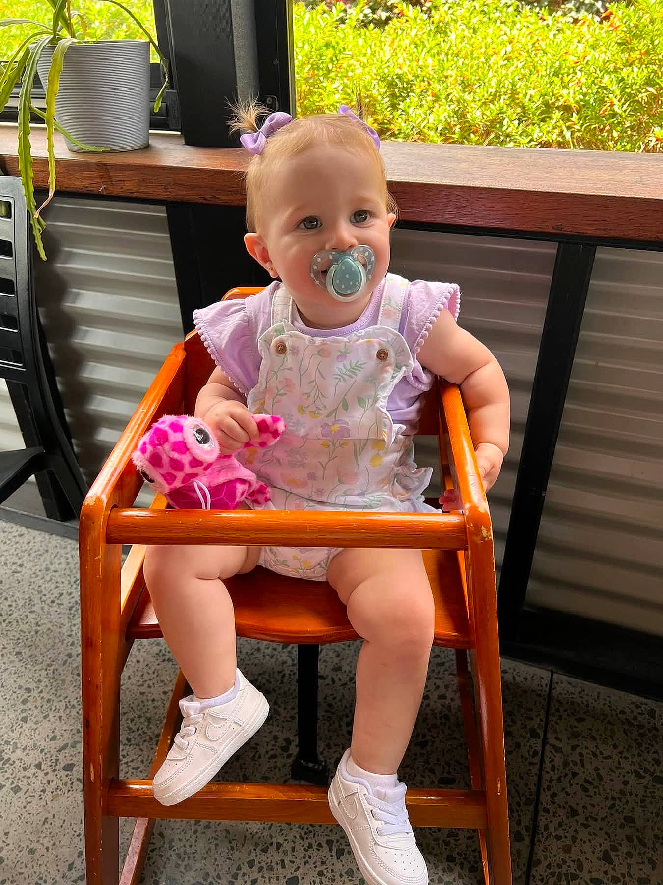 Azalia is registered to the contest to win money with this photo: baby, chair, clothing, face, flower, footwear, furniture, grass, head, jar, person, photography, plant, planter, portrait, pottedplant, pottery, shoe, sitting, vase