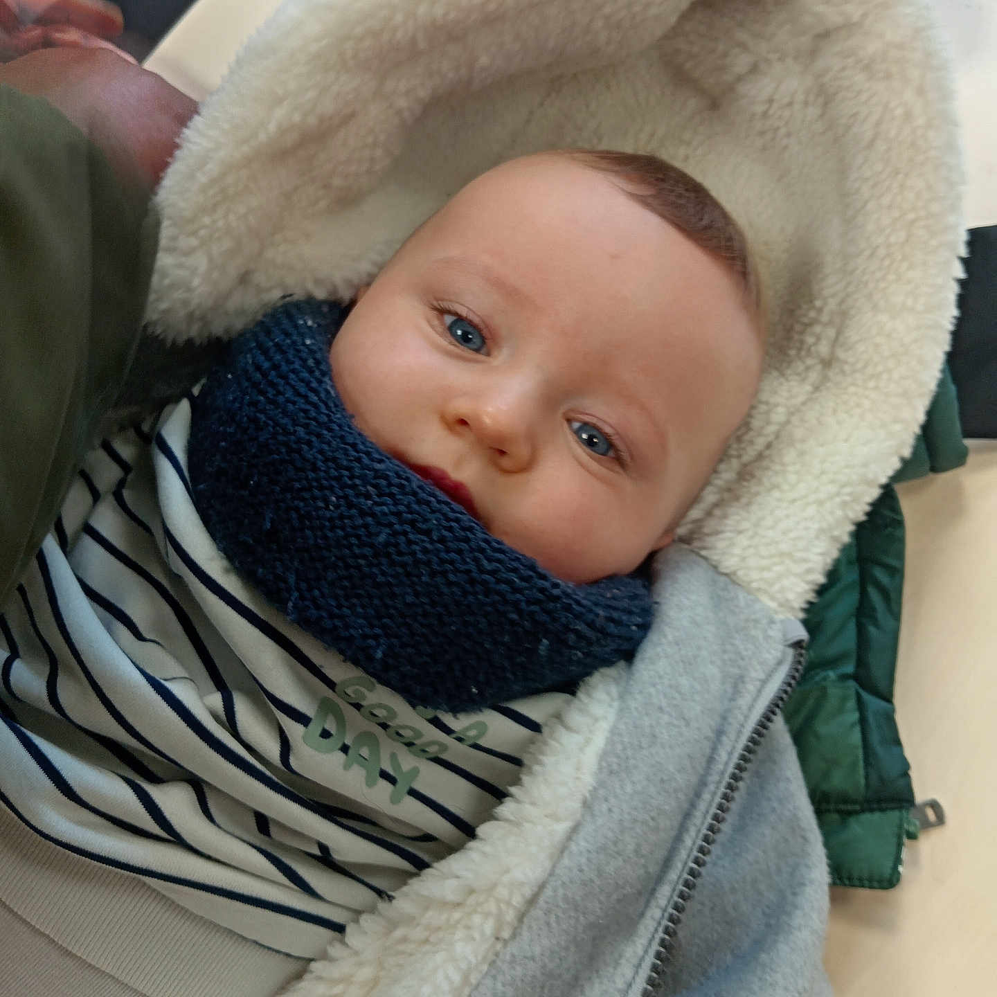 Ezio participe au concours pour gagner de l'argent avec cette photo : baby, blue_eyes, child, closeup, clothing, cozy, cute, face, hood, indoor, infant, jacket, person, portrait, scarf, smile, soft_texture, striped_shirt, warm, young_child
