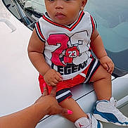 Carmelo joined the competition — help win amazing prizes! baby, basketball_jersey, car, casual, child, curious_expression, daylight, fashion, grass, hand, hood, outdoor, person, portrait, sneakers, sporty_outfit, supporting_hand, toddler, vehicle, young_child
