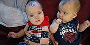 Zayleigh joined the competition — help win amazing prizes! baby, infant, child, couch, clothing, dress, onesie, red_bow, fireworks, sitting, face, cute, indoor, portrait, two_children, expression, curious, skin, head, person