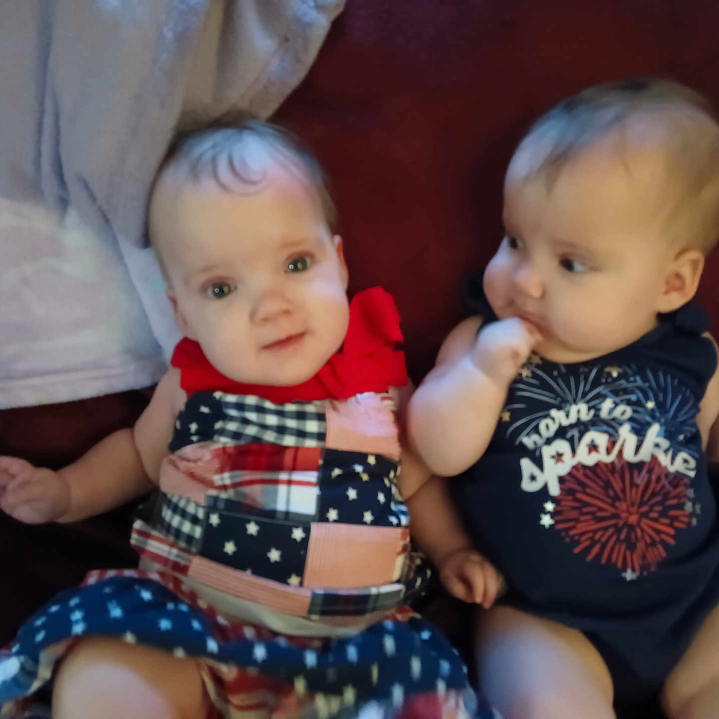 Zayleigh joined the competition — help win amazing prizes! baby, child, clothing, couch, curious, cute, dress, expression, face, fireworks, head, indoor, infant, onesie, person, portrait, red_bow, sitting, skin, two_children