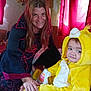 woman, child, costume, yellow, lion, burger_king, bag, indoor, curtains, red, smile, bed, plush, person, clothing, furniture, home, portrait, happy, casual