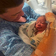 Harley is registered to the contest to win money with this photo: newborn, baby, mother, hospital, medical, gown, blanket, bed, infant, patient, healthcare, tenderness, love, family, care, woman, person, indoor, closeup, rest
