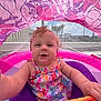 baby, child, infant, smiling, swimsuit, inflatable, float, pool, water, wet_hair, canopy, pink, purple, toy, splash, portrait, close_up, summer, outdoor, palm_tree