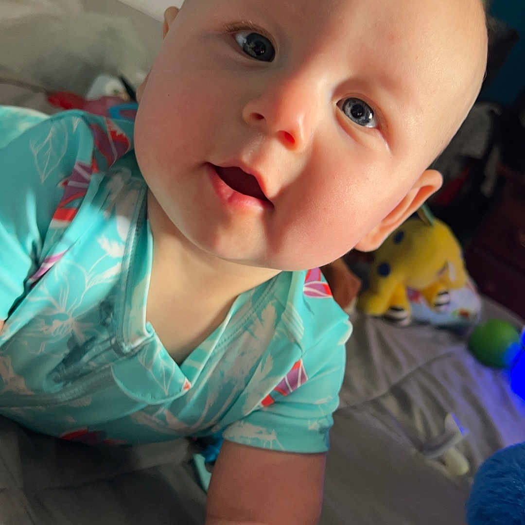 Andy is registered to the contest to win money with this photo: baby, bed, bedroom, bodypart, clothing, couch, crawling, cushion, face, finger, furniture, hand, head, homedecor, indoors, person, photography, portrait, room, t_shirt