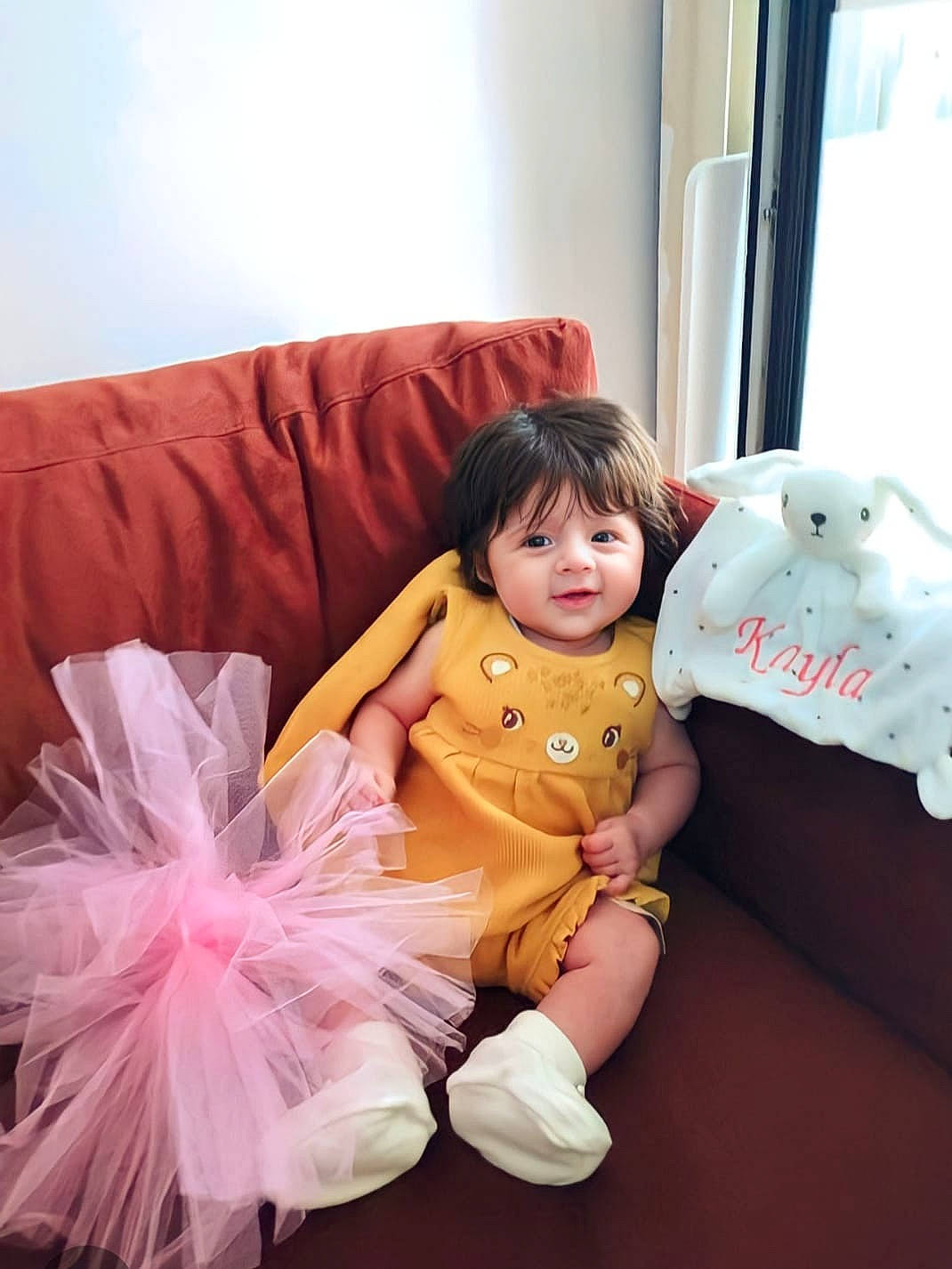 Kayla participe au concours pour gagner de l'argent avec cette photo : baby_toddler_clothing, ballet_tutu, child, comfort, costume, couch, event, fashion_accessory, fun, happy, linens, magenta, person, pink, room, sitting, sleeve, sock, stuffed_toy, textile