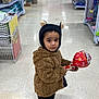 Mannat joined the competition — help win amazing prizes! child, kid, store, aisle, lollipop, hat, bear_ears, jacket, brown_jacket, black_hat, shoes, white_shoes, floor, shelves, products, shopping, curious, standing, indoors, portrait